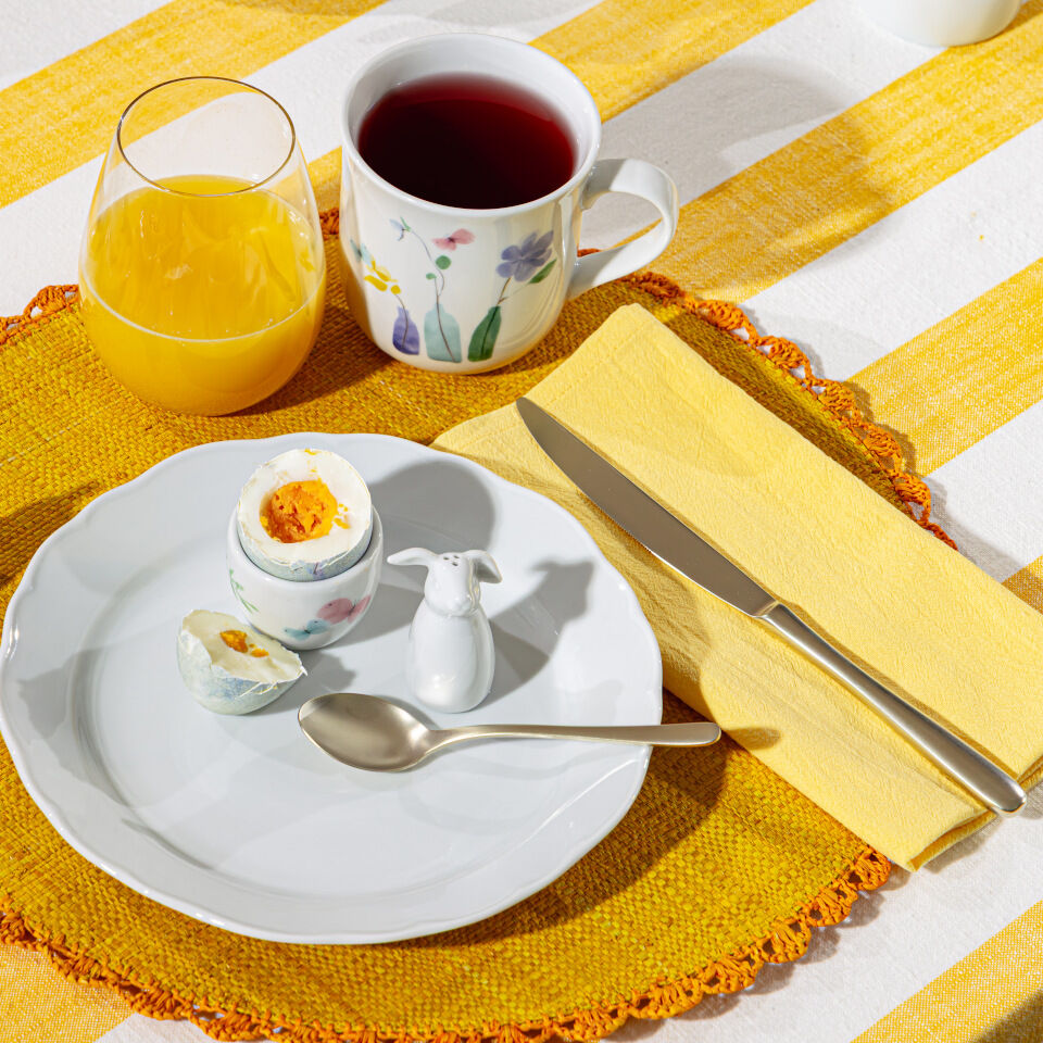 Geschirr Fr&uuml;hlingsgr&uuml;&szlig;e auf gelber Tischdecke