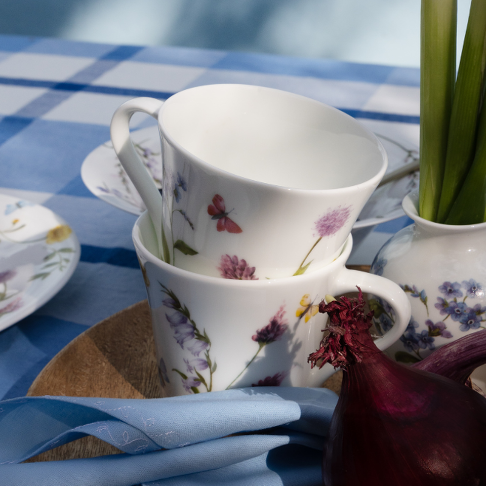 Due tazze Hutschenreuther con motivi floreali su una tavola apparecchiata.