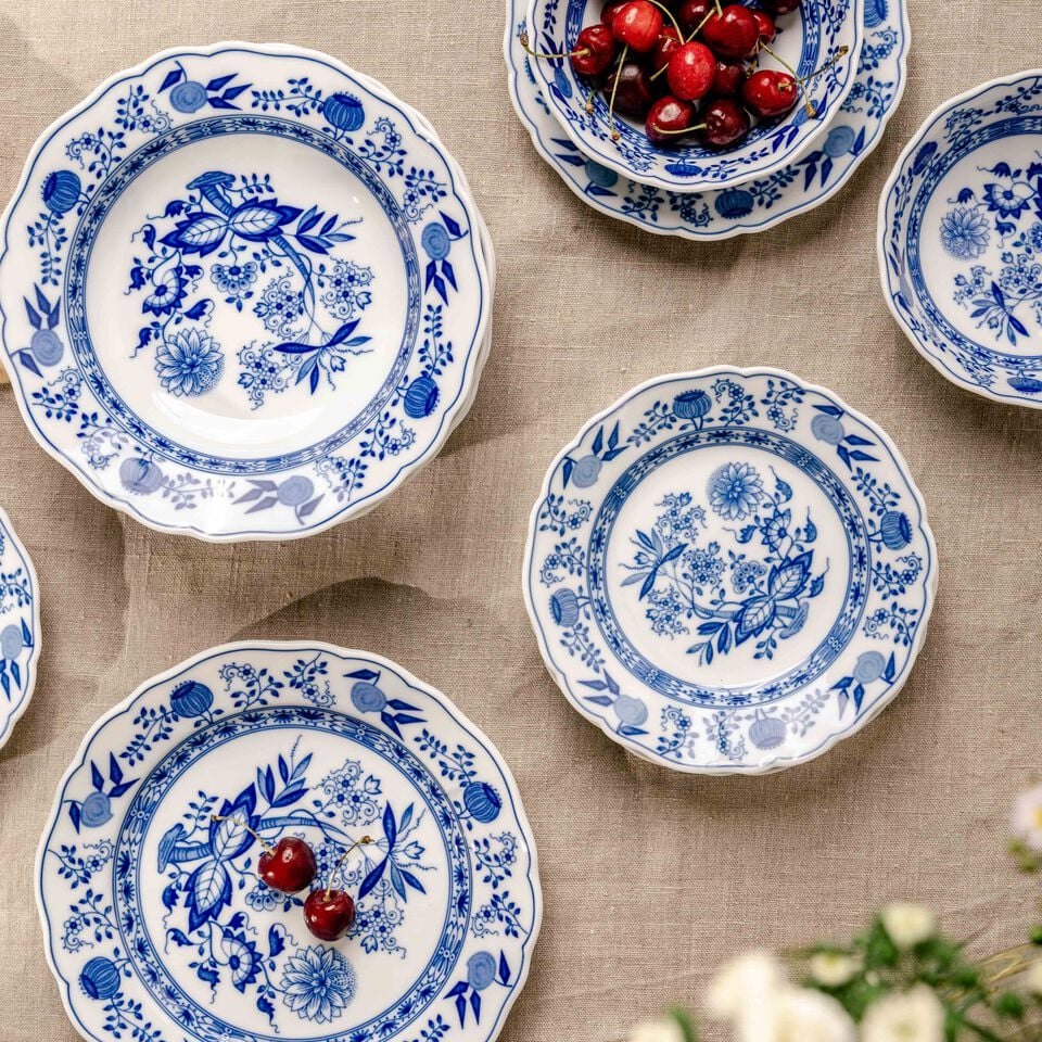 Hutschenreuther blue onion pattern plates on linen cloth, bowl with cherries.