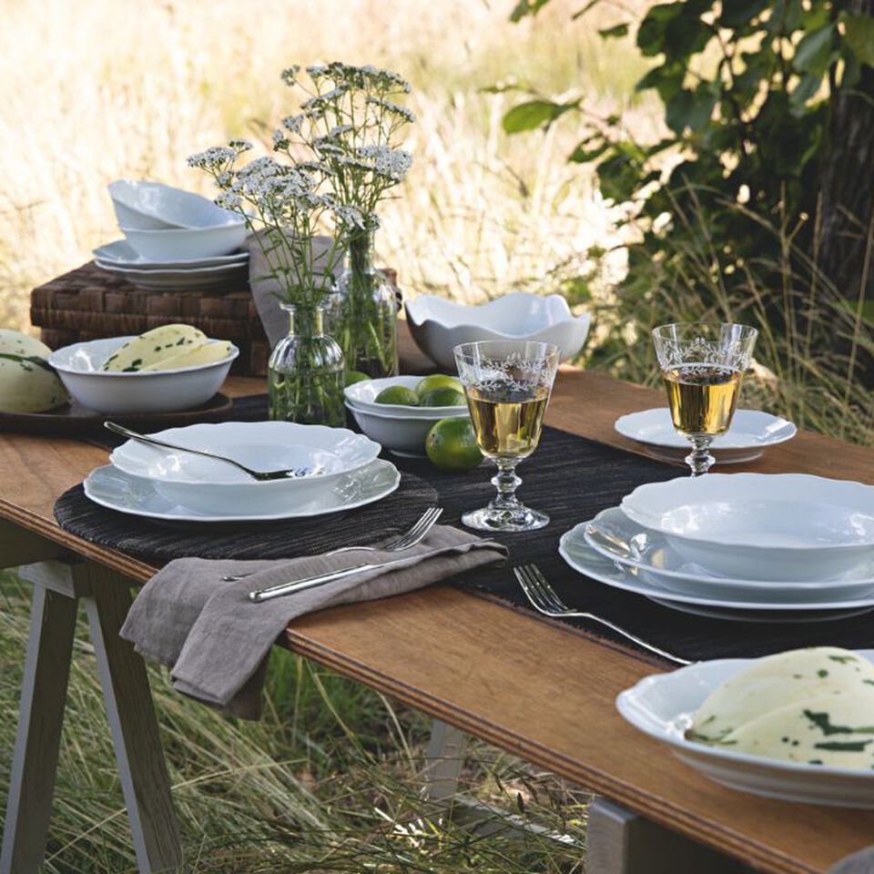 Summer table setting with white outdoor tableware.