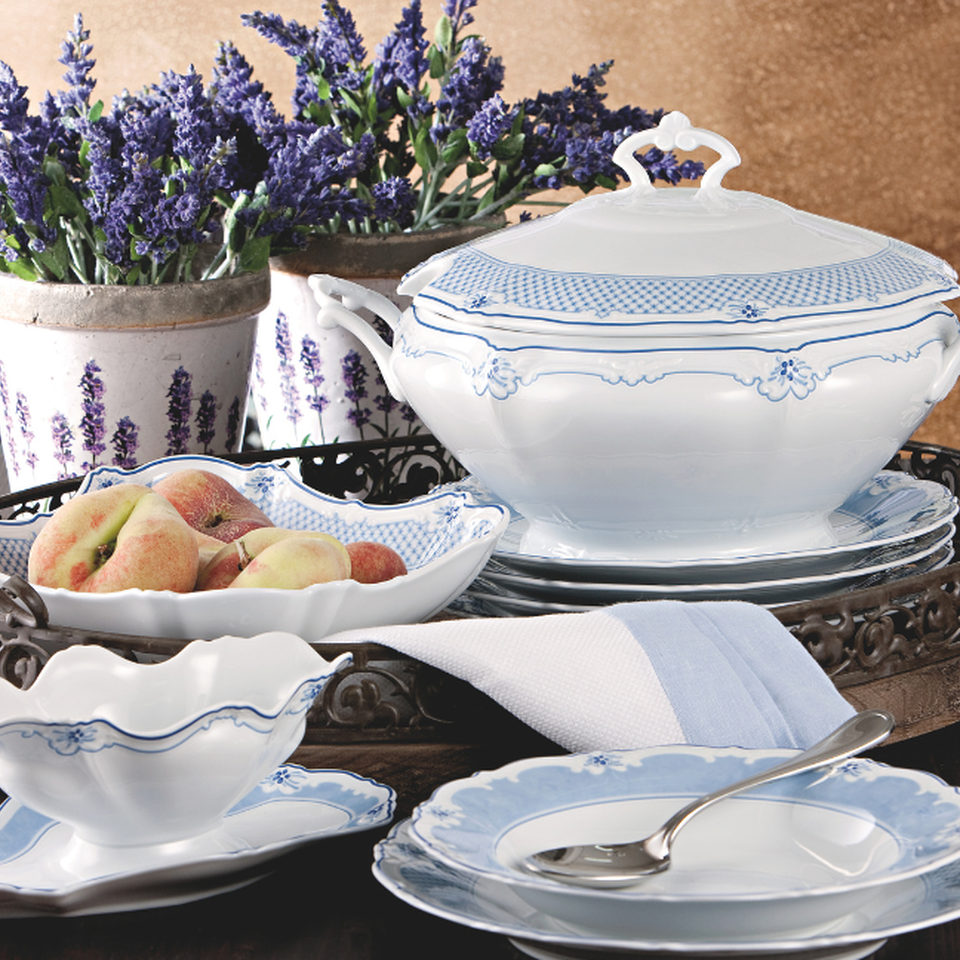 Elegante servizio Hutschenreuther blu e bianco con zuppiera, ciotole e piatti davanti a pentole con fiori di lavanda