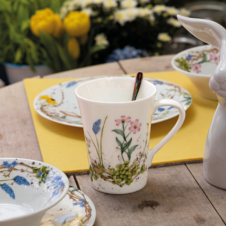Hutschenreuther Süße Ostern Henkelbecher mit Frühlingsblumen auf einem Gartentisch aus Holz