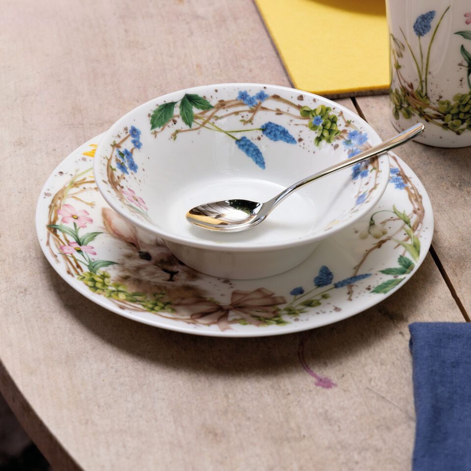Hutschenreuther Süße Ostern Bowl auf einem Teller dekoriert mit Frühlingsblumen auf einem Holztisch