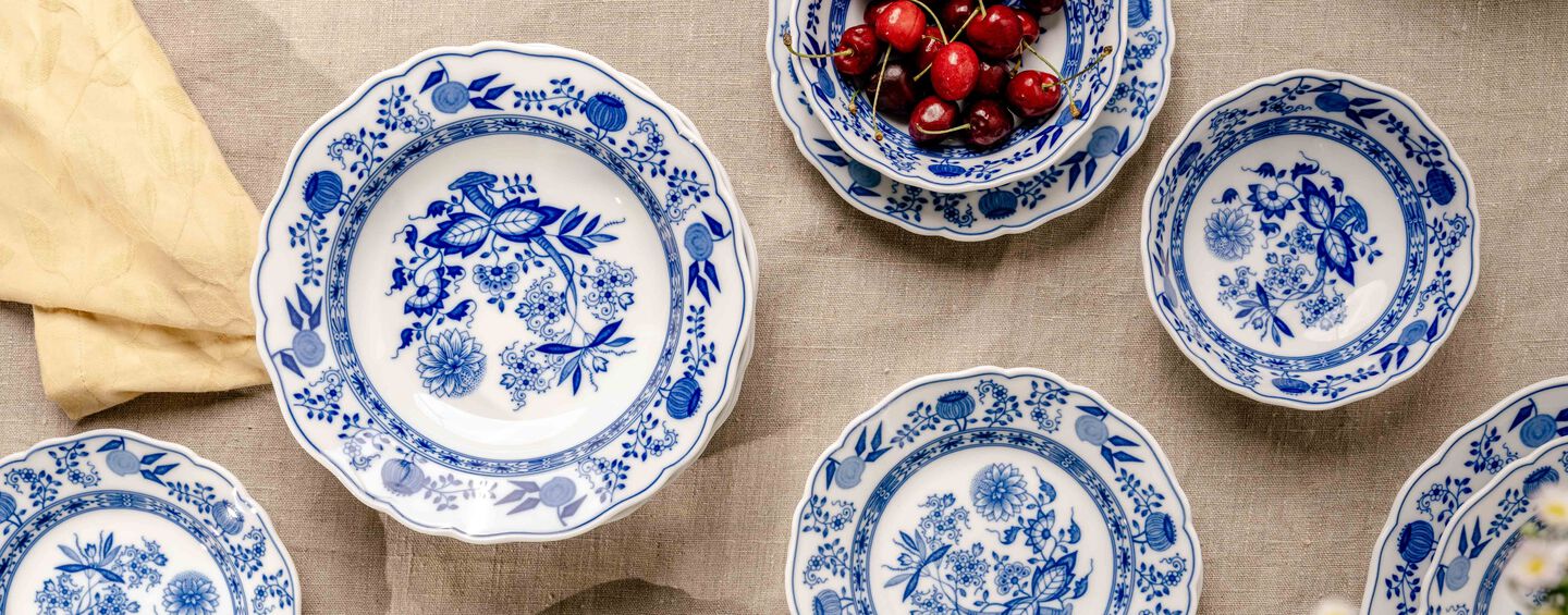 Blue and white porcelain tableware by Hutschenreuther with classic onion pattern on linen tablecloth, top view