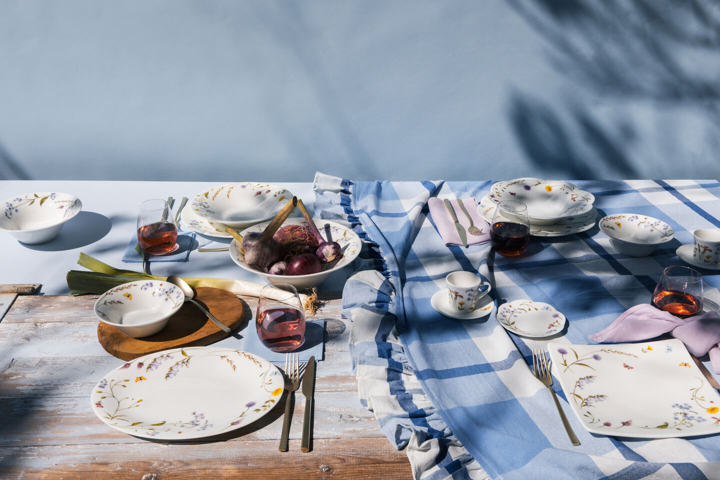 Hutschenreuther tableware with floral patterns on a set outdoor table with plates, bowls and cups in pastel colours.