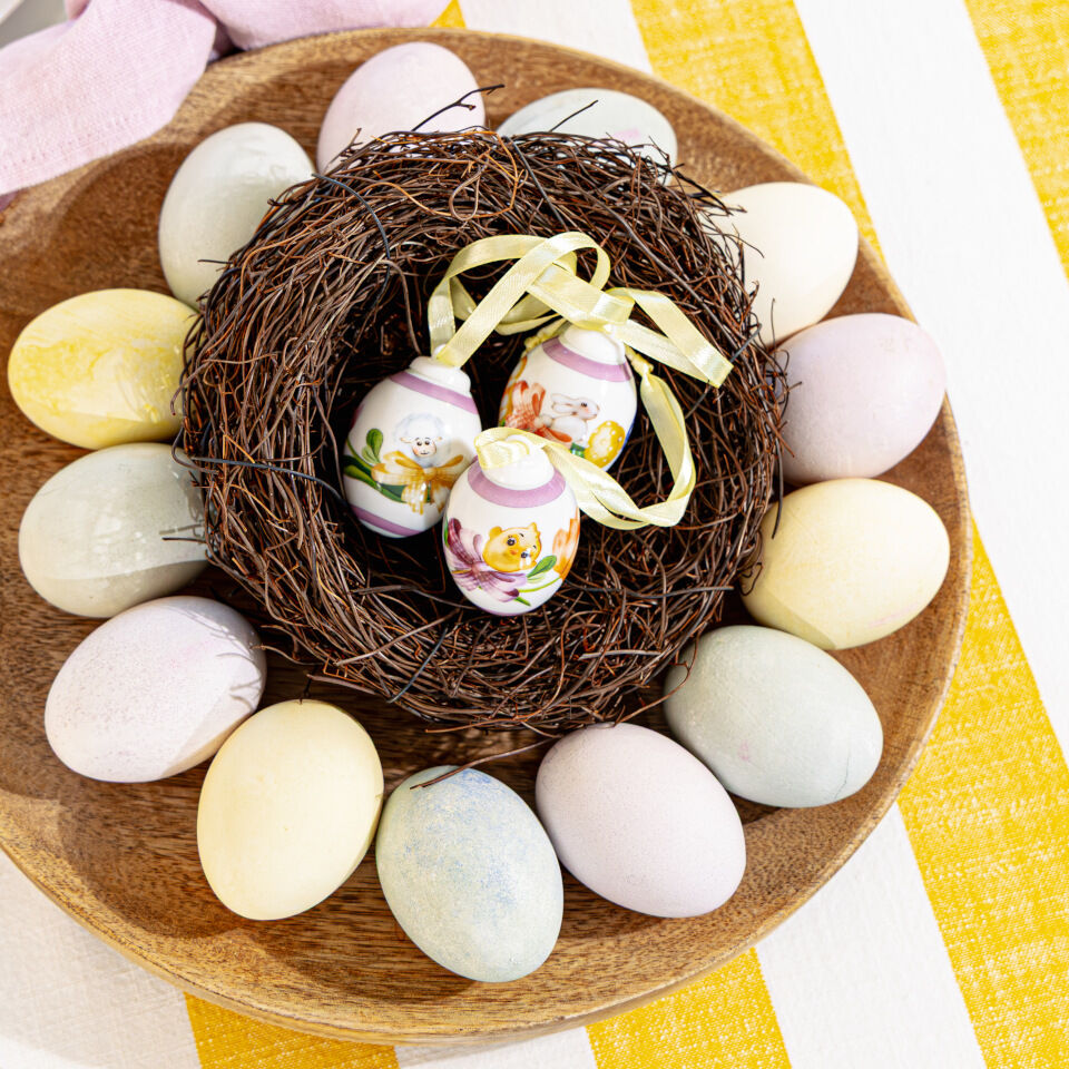 Decorazioni pasquali Hutschenreuther con uova di Pasqua in porcellana nel nido, circondate da uova di Pasqua dai colori pastello.