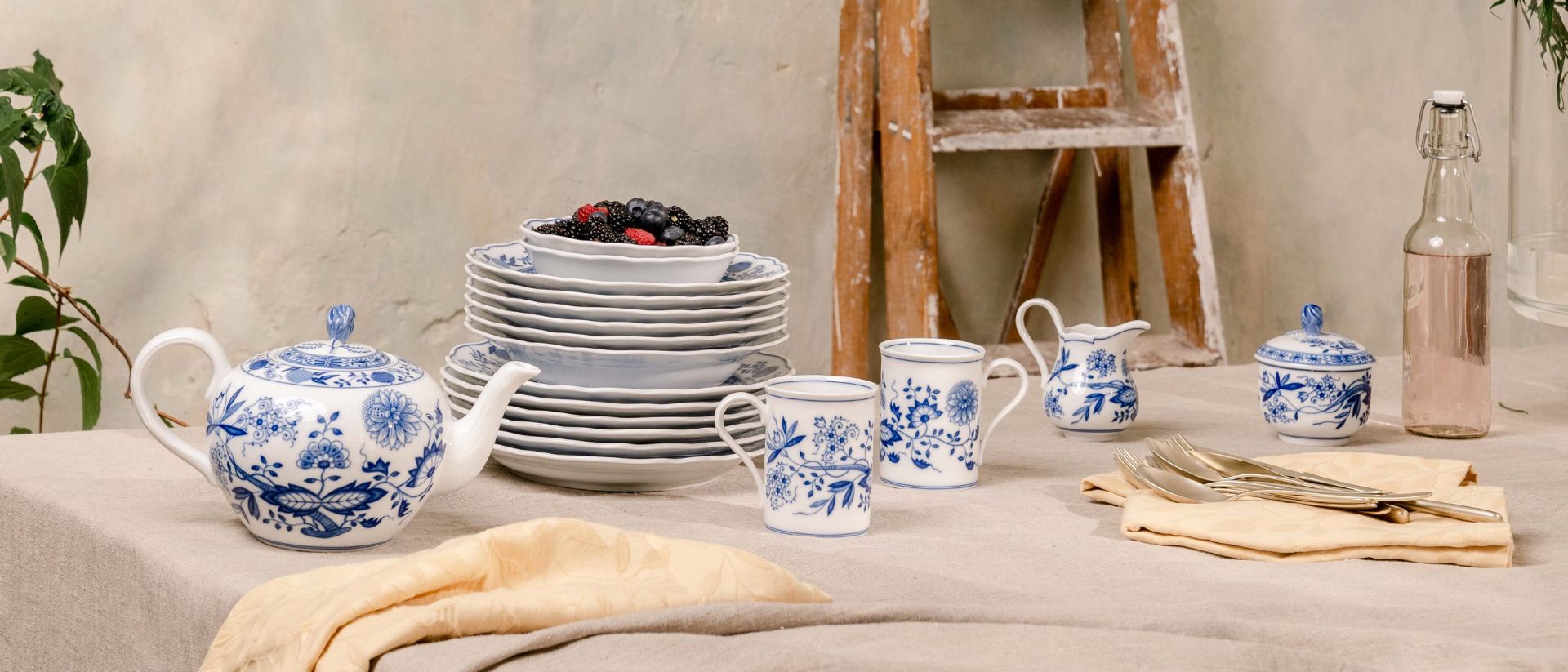 Table with Hutschenreuther blue onion, berries and flowers.