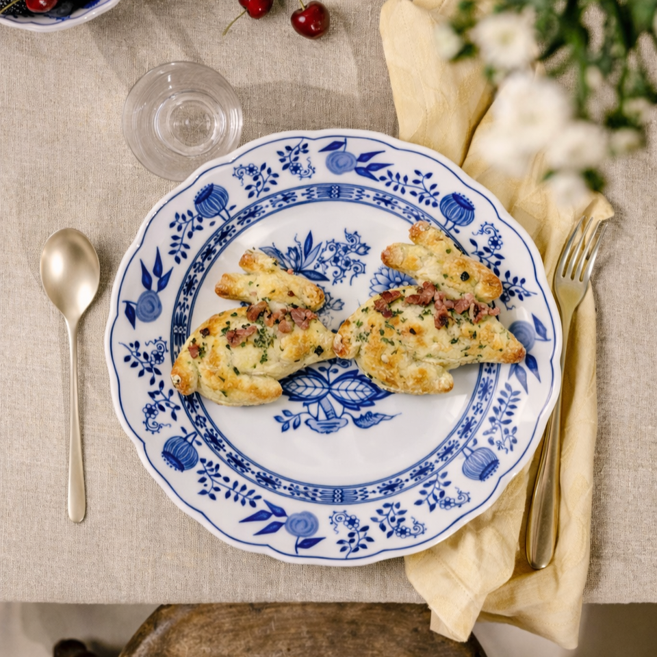 Coniglietti pasquali di pasta sfoglia con formaggio e pancetta su piatto di porcellana blu e bianco Hutschenreuther.
