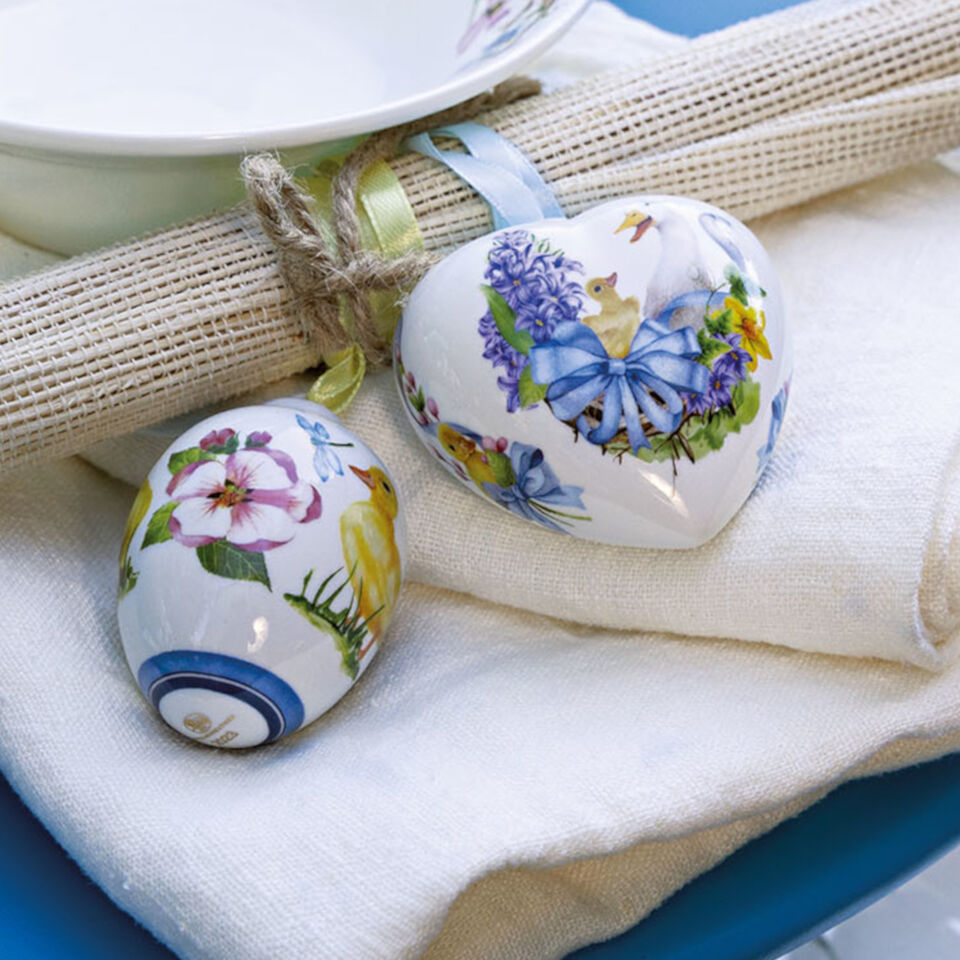Hutschenreuther Osteranhänger Herz und Ei auf weißer Serviette auf blauem Tisch