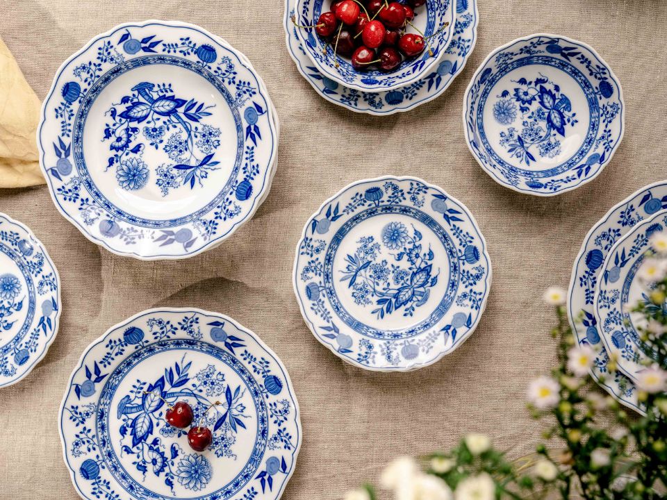 Piatti con decoro cipolla su lino, decorati con ciliegie.