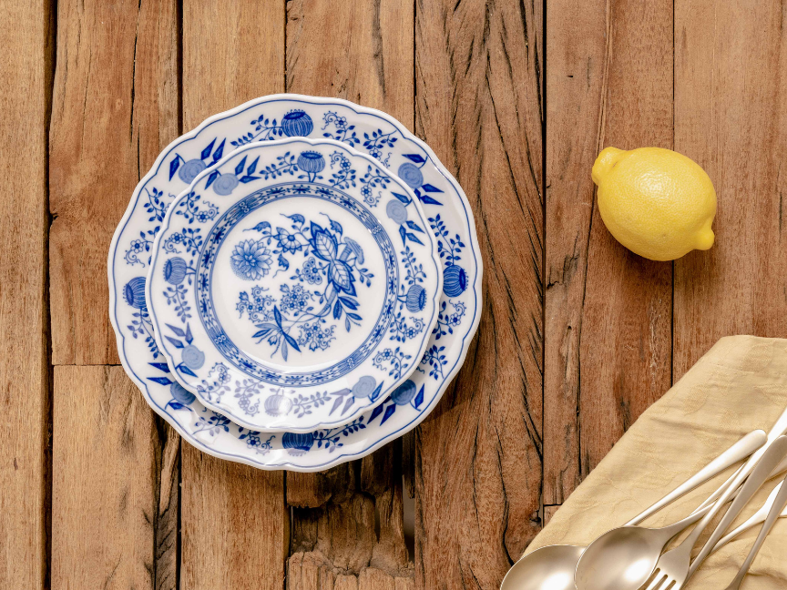 Classic Hutschenreuther porcelain in blue and white with onion decoration, arranged on a wooden base with lemon and cloth napkin