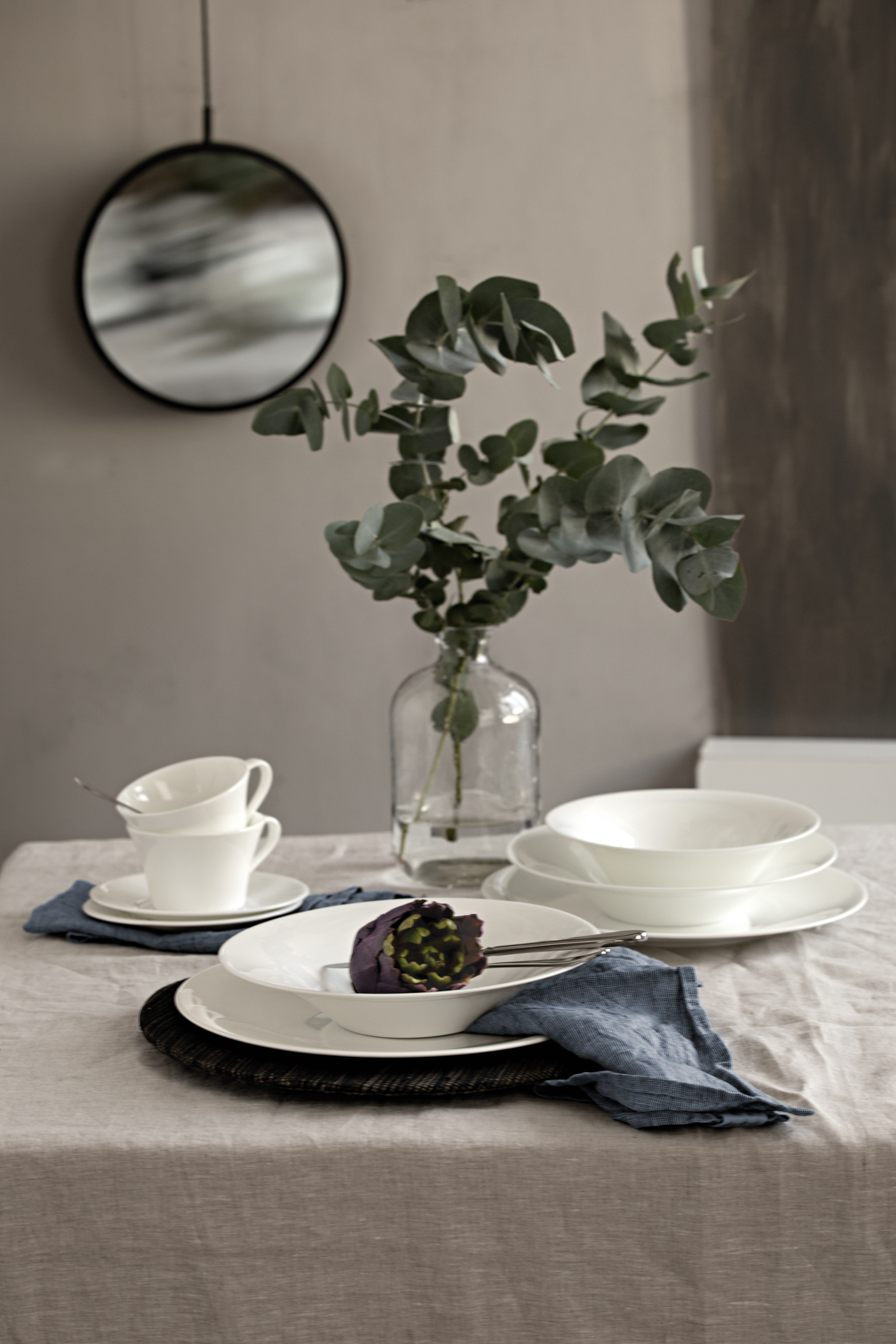 Hutschenreuther Nora White plates, cups decorated with eucalyptus branches in glass vase on table